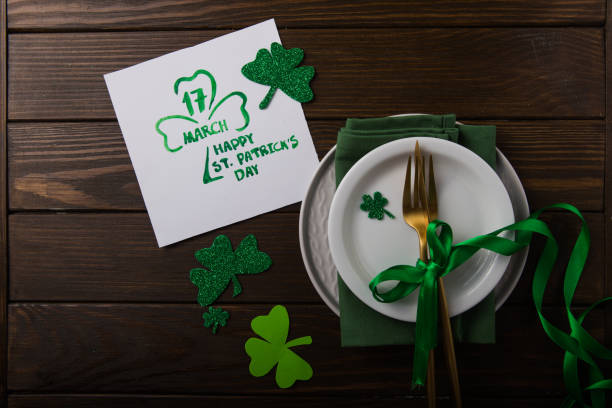 istock St Patrick's Day party table setting decorated with green leprechaun on wooden background. 1198139783