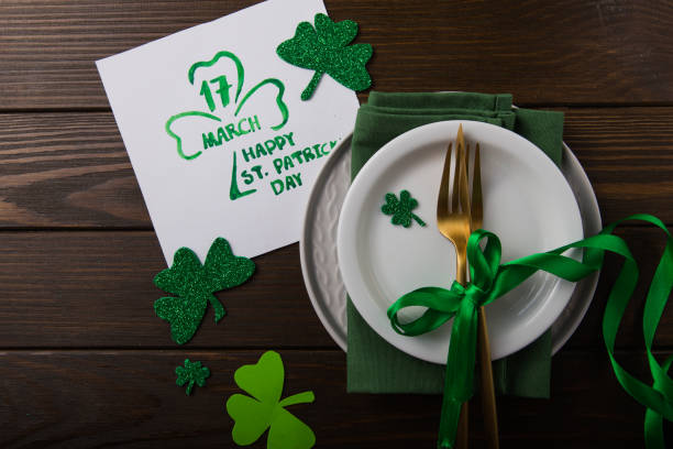 istock St Patrick's Day party table setting decorated with green leprechaun on wooden background. 1198139785