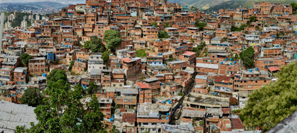 Aerial view of Caracas at sunset with the David Tower landmark skyscraper and slums visible. Drone shot of the venezuelan capital at sunset. Concept of development in a developing country