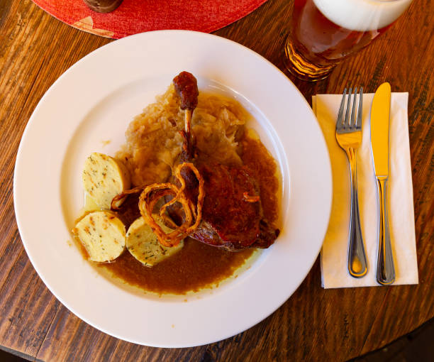 Roasted confit du canard with sauerkraut, potato dumplings and onion
