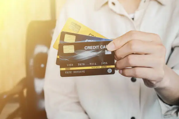 Photo of Cropped shot view of female hands showing her credit cards.
