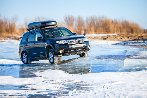 Khabarovsk, Russia - January 4, 2020: Subaru Forester at frozen lake ice. Ice waves