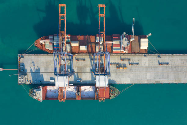 istock Container ship in export and import business and logistics. Shipping cargo to harbor by crane. Water transport International. Aerial view and top view. 1198153897