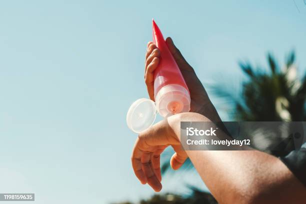 Nahaufnahme Junge Frau Anwendung Sonnencreme Lotion Auf Der Hand Mit Blauen Himmel Hintergrund Stockfoto und mehr Bilder von Sonnencreme