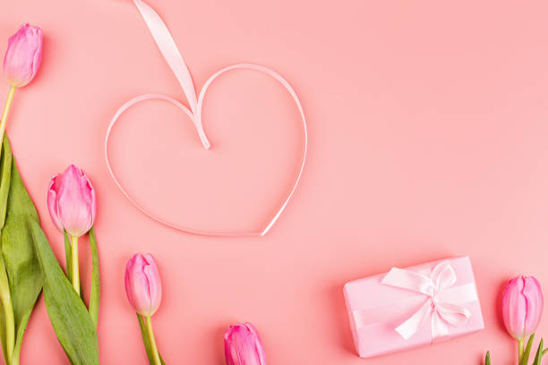 istock View from above tulips and gift box with copy space. Background for womens day, 8 March Valentines day, 14 february. Flat lay style, top view, mockup, template, overhead. Greeting card 1198162457