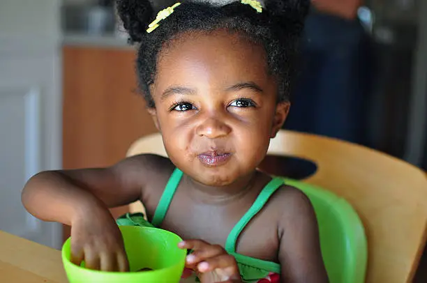 Photo of A young girl eating grapes out of a bowl