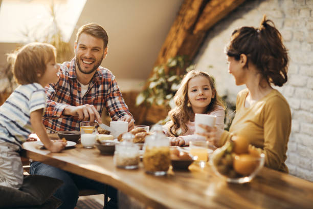 istock Young happy parents talking to their kids during breakfast time at dining table. 1198174873