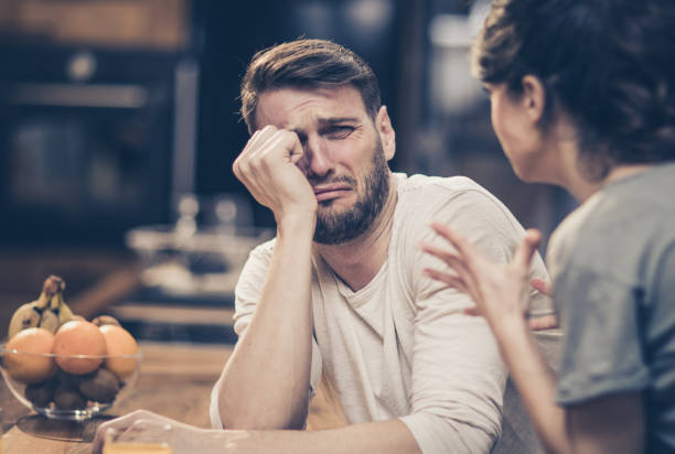 Please, don yell at me! Depressed man feeling fear while his wife is angry at him. man crying stock pictures, royalty-free photos & images