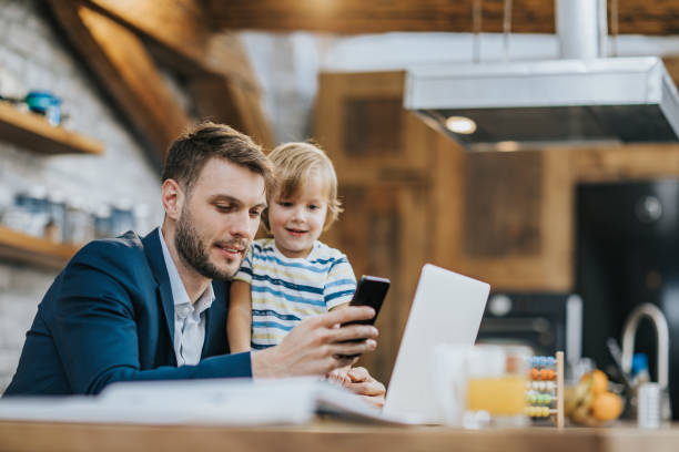 istock Young business father and his son using cell phone at home. 1198179383