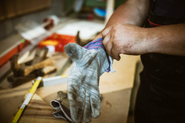 Mechanic wears gloves fixing motorbike in workshop garage, Man repairing motorcycle in repair shop, Repairing and maintenance concepts