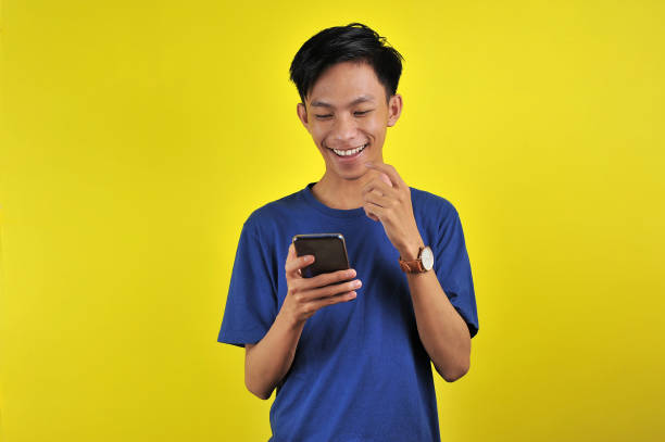 istock Happy of young good looking Asian man smiling using smartphone 1198194841