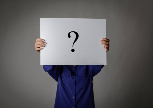 istock Young woman in blue is holding white paper. Question Mark. 1198196145