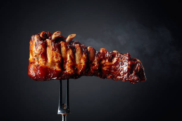 Grilled pork ribs on a fork. Grilled pork ribs on a fork. Copy space. smoked pork stock pictures, royalty-free photos & images