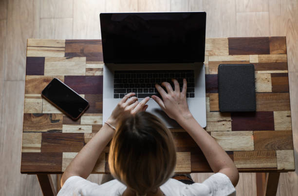 istock Woman's hands typing on laptop keyboard. Study and work online, freelance. Self employed or freelance woman, girl working with her laptop sitting at wooden table with a phone, smartphone and ereader. 1198198671