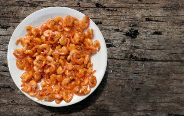 istock Prawn or Shrimp Fried in a plate isolated on wooden background with copy space 1198200745