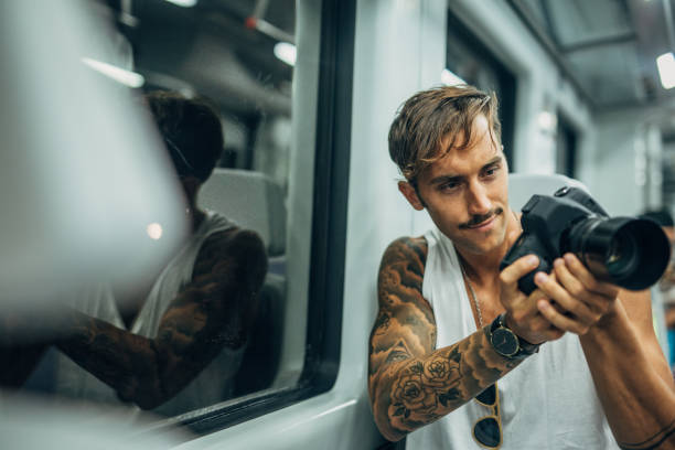 istock Man with digital camera riding in subway train 1198202360