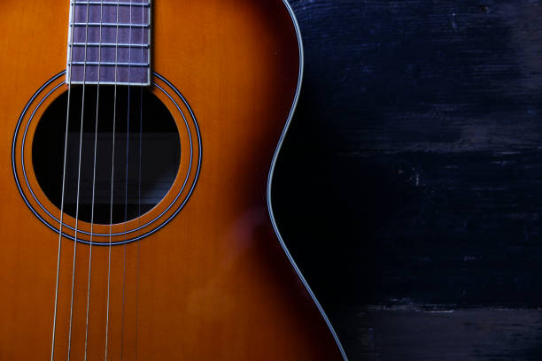 istock Six string folk acoustic guitiar over aged wood background. 1198202458