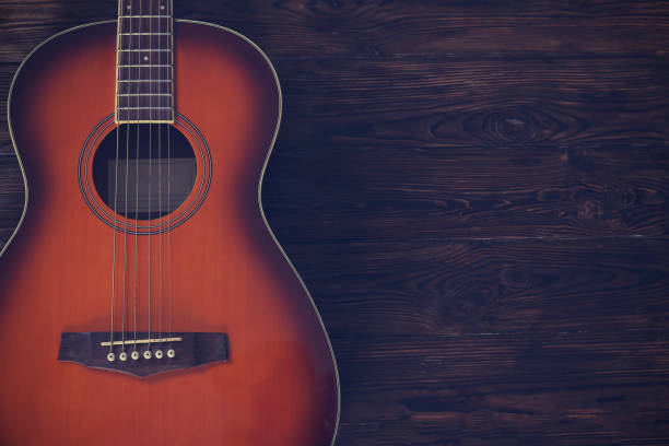 istock Six string folk acoustic guitiar over aged wood background. 1198202522