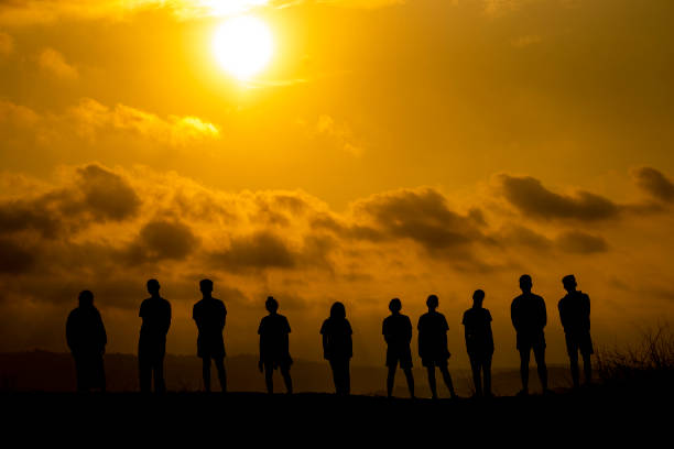 istock Silhouette People Standing On Land Against Cloudy Sky During Sunset 1198206240
