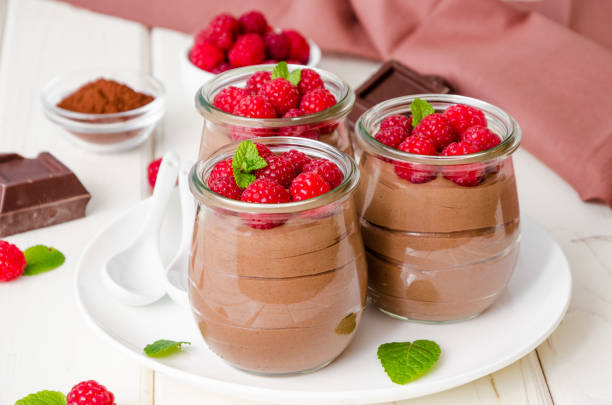 istock Chocolate pudding (mousse) with fresh raspberries in glass jars on a white wooden background. Dessert on Valentine's Day and Women's Day. 1198210507