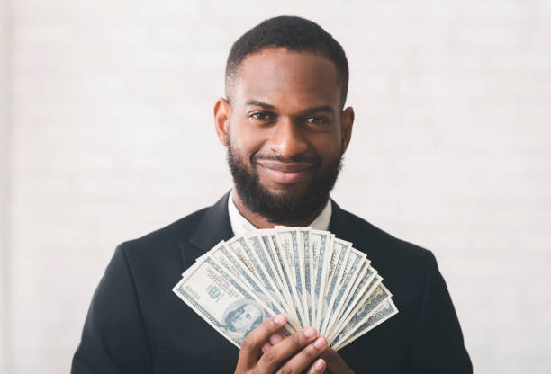 giovane uomo d'affari nero di successo che tiene i soldi sul backgrpund bianco - excitement business person ecstatic passion foto e immagini stock