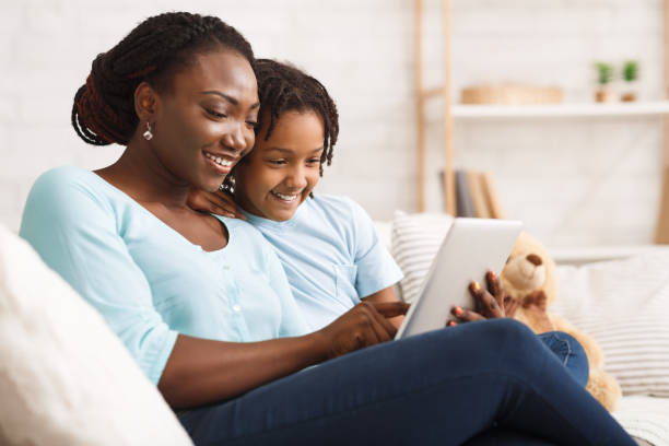 istock Happy black family spending time together using tablet 1198211282