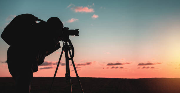 istock photographer with tripod and camera 1198216478