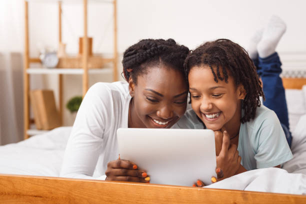 black mother and daughter making video call to dad - laptop women child digital tablet imagens e fotografias de stock
