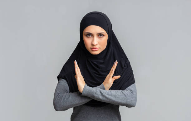 istock Islamic woman makes denial hand gesture, keeps arms crossed, rejecting something 1198217745