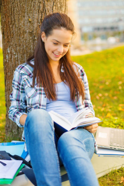 istock smiling teenager reading book 1198217917