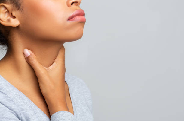 Black woman touching her neck, having pain in throat Cropped of afro woman touching her neck, having pain in throat, free space follicular thyroid cancer stock pictures, royalty-free photos & images