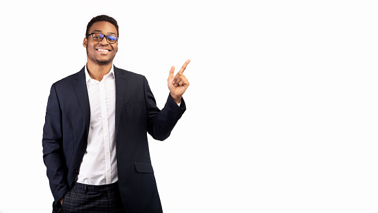 Best Choice. Smiling black businessman pointing at blank space, looking at camera. Panorama, place for text or promo