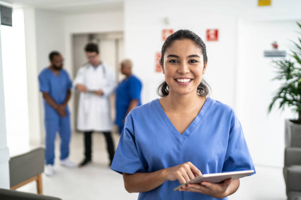 porträtt av kvinnlig sjuksköterska använda tablett på sjukhus - smiling nurse bildbanksfoton och bilder