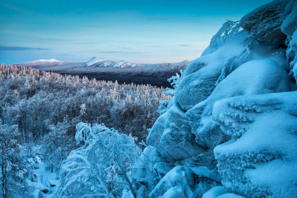 istock Rock, snow capped mountains and winter forest in the evening light 1198225385