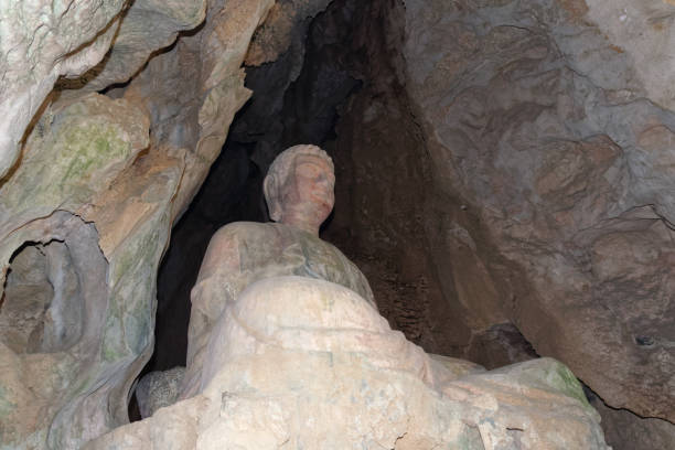 istock Low angle view of stone Buddha in a cave 1198226058