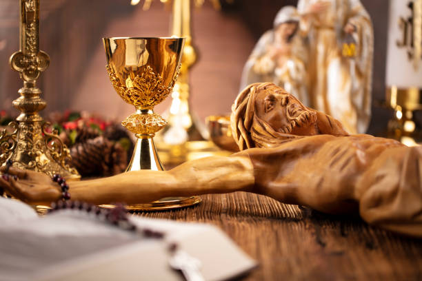 Catholic concept background. The Cross, monstrance, Jesus figure, Holy Bible and golden chalice on the rustic wooden table. liturgy photos stock pictures, royalty-free photos & images