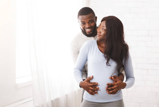istock Pregnant black lady looking at her smiling husband 1198229493