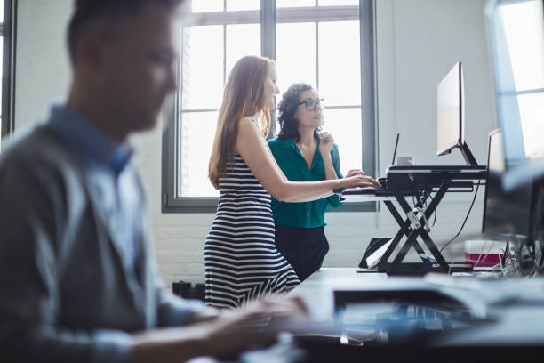 Two businesswomen working on standing desk.