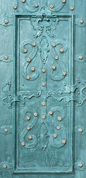 istock Beautiful forged patterns on an emerald-colored door. Close-up 1198229718