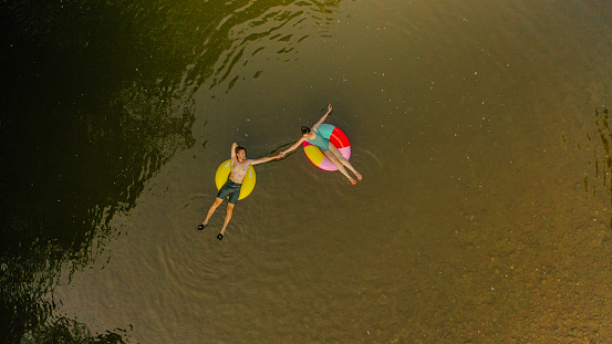 Photo of a young couple on inflatable rings in the river