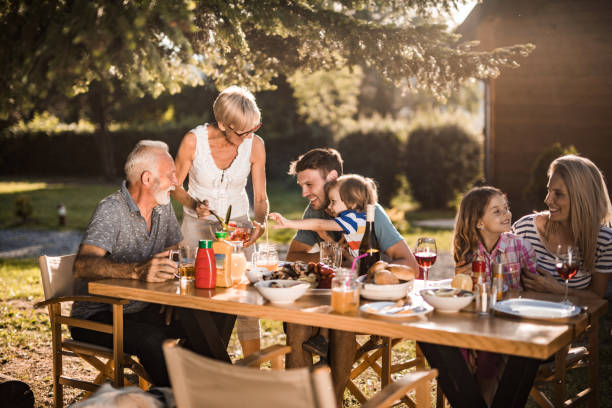istock Happy extended family talking while having their lunch in the front yard. 1198231236
