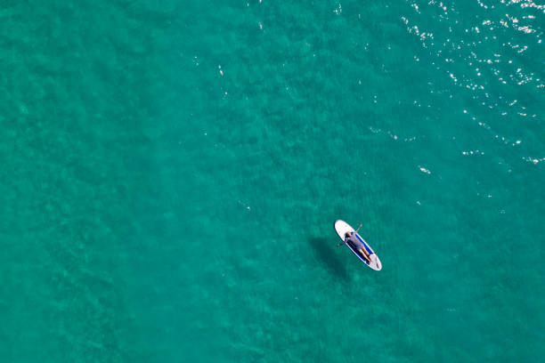 istock Man relaxing on his paddle board in the sea 1198231448