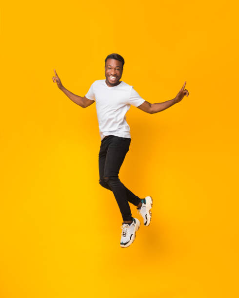 istock Afro Man Having Fun Jumping In Air Over Yellow Background 1198232256