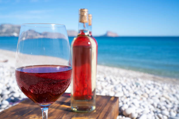 istock Red wine and wine glass on the beach 1198232405