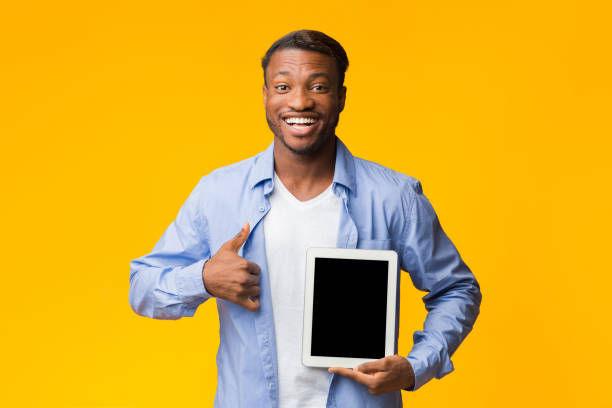 istock Afro Man Showing Tablet Screen Gesturing Thumbs-Up, Mockup, Studio Shot 1198232531