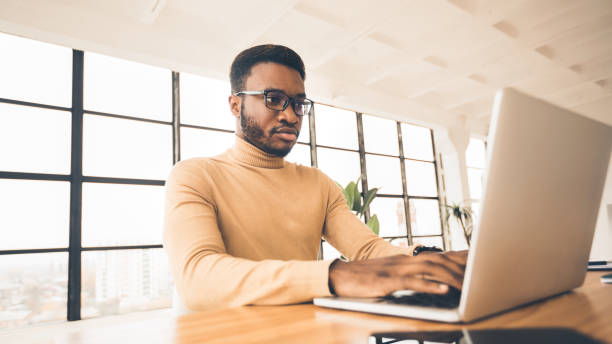 istock Concentrated african american man working with laptop 1198232551