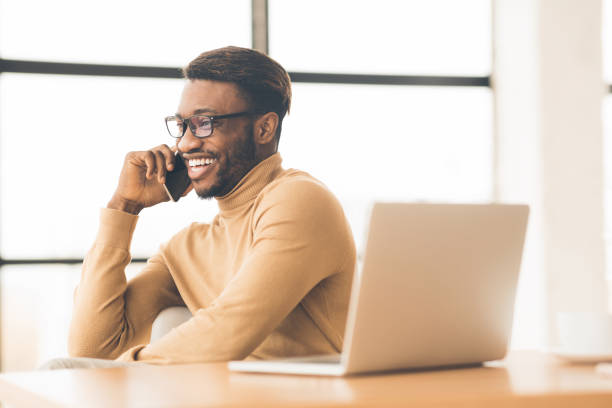 istock Cheerful black guy talking on the phone 1198233467
