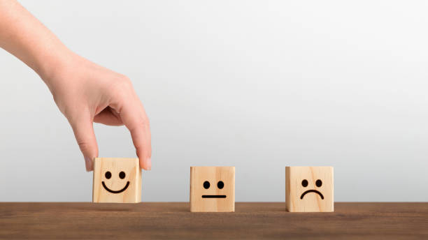 istock Hand picked the happy face smile symbol on wooden cube 1198233546