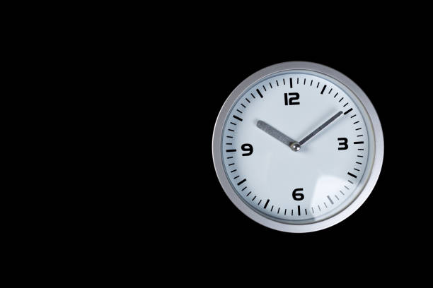 minimalist white wall clock with light metal on a black background. time concept.