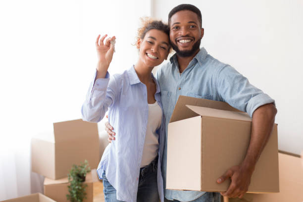 istock Joyful Afro Spouses Showing Key Embracing Holding Box After Relocation 1198235188